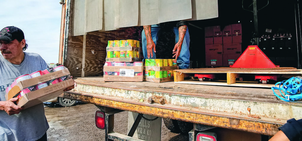 Day laborers and volunteers unload non-perishable foods from a truck during an emergency delivery by the Food Distribution Program in Oglala, S.D., on the Pine Ridge Indian Reservation, March 22, 2019. On Pine Ridge, extreme weather and bad roads have set off a humanitarian disaster that seems unlikely to abate soon. (Kristina Barker/The New York Times)