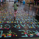 A memorial in the street near the site of the murder of George Floyd lists names of people killed by police